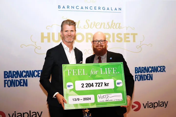 <p>Profeel räcker över checken till Barncancerfonden.</p>
